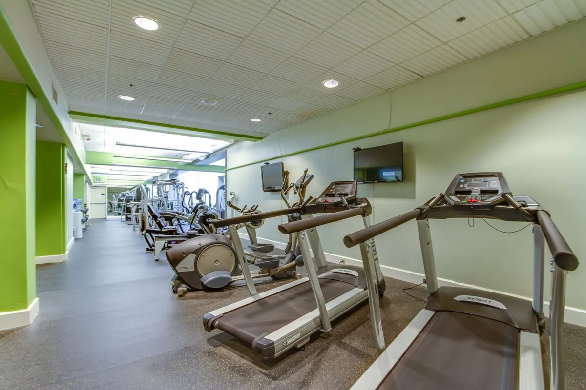 A well-equipped fitness center featuring treadmills, ellipticals, and television screens. The atmosphere is active and motivating, ideal for post-adventure workouts or keeping up with fitness routines during your stay.